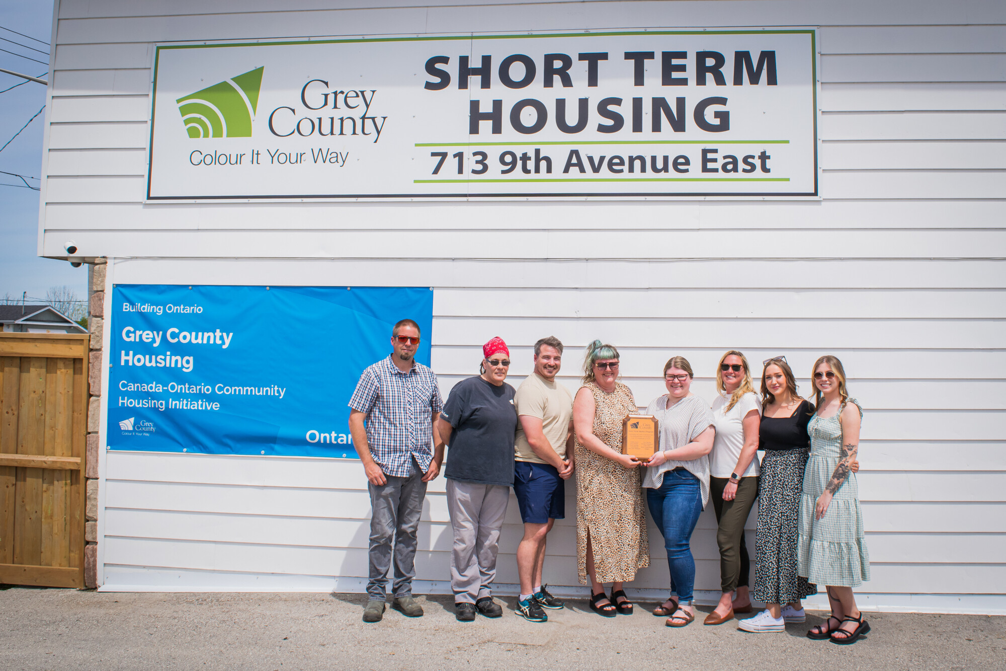 Emergency Housing Program staff pose in front of the motel at 713 9th Avenue East. 