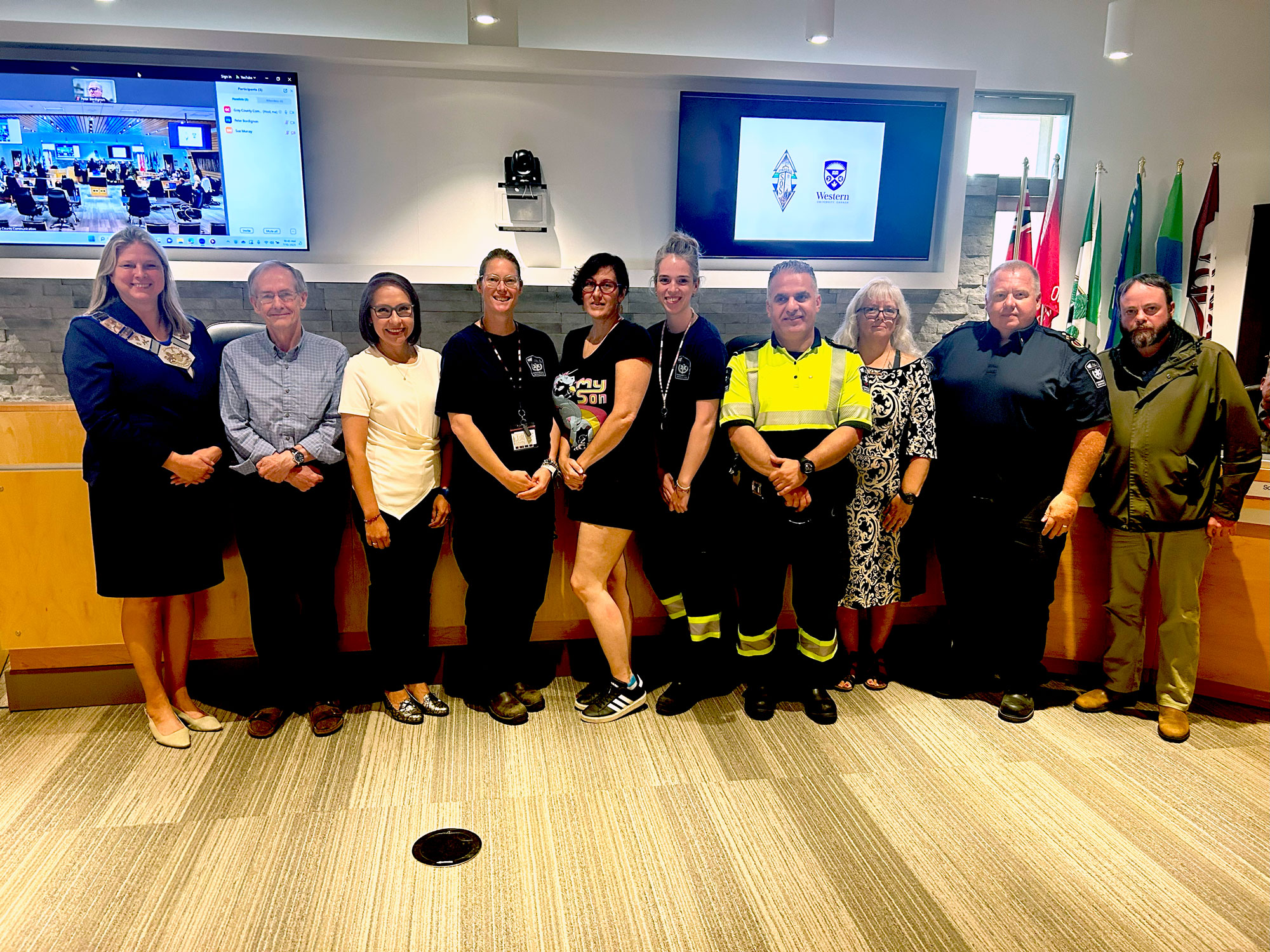 SOS report authors Dr. Eby and Dr. Cristancho pose in Council Chamber with Warden Andrea Matrosovs and members of the SOS Team. 