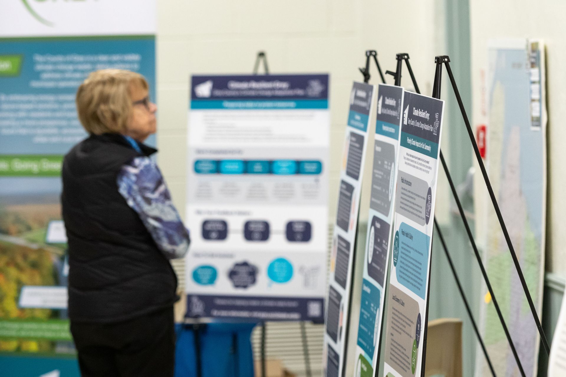 Older woman looking at Resilient Grey posterboards at a community event