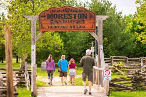 A family of four walking into Moreston Heritage Village.