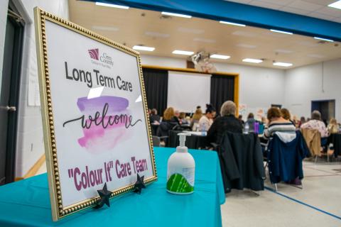 Staff listening to an instructor in a gymnasium.  