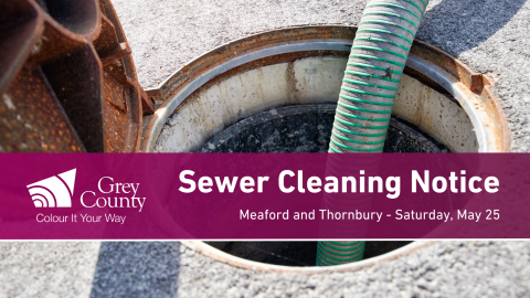 image of a large hose being inserted into a manhole. 