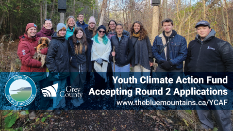 A group of youth from St. Mary's High School in owen sound stand with Warden matrosovs in a forest. 