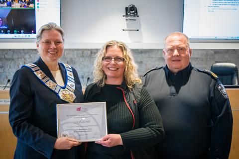 Colleen Trask-Seaman accepts a certificate of appreciation on behalf of OSHaRE from Warden Andrea Matrosovs (left) and Paramedic Chief Kevin McNab (right)