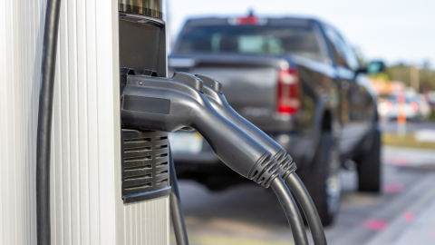 Electric vehicle charging station with truck in the background. 