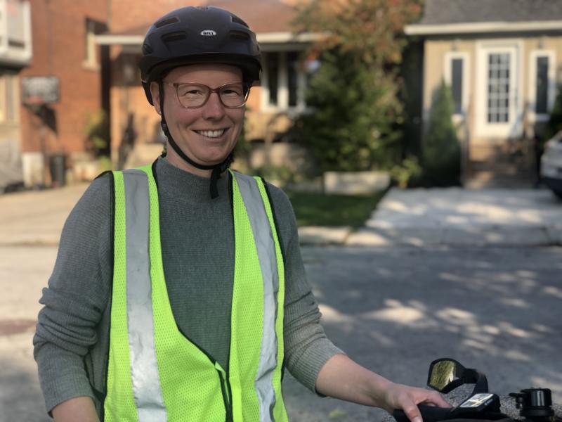 Linda standing with her e-bike and wearing a helmet