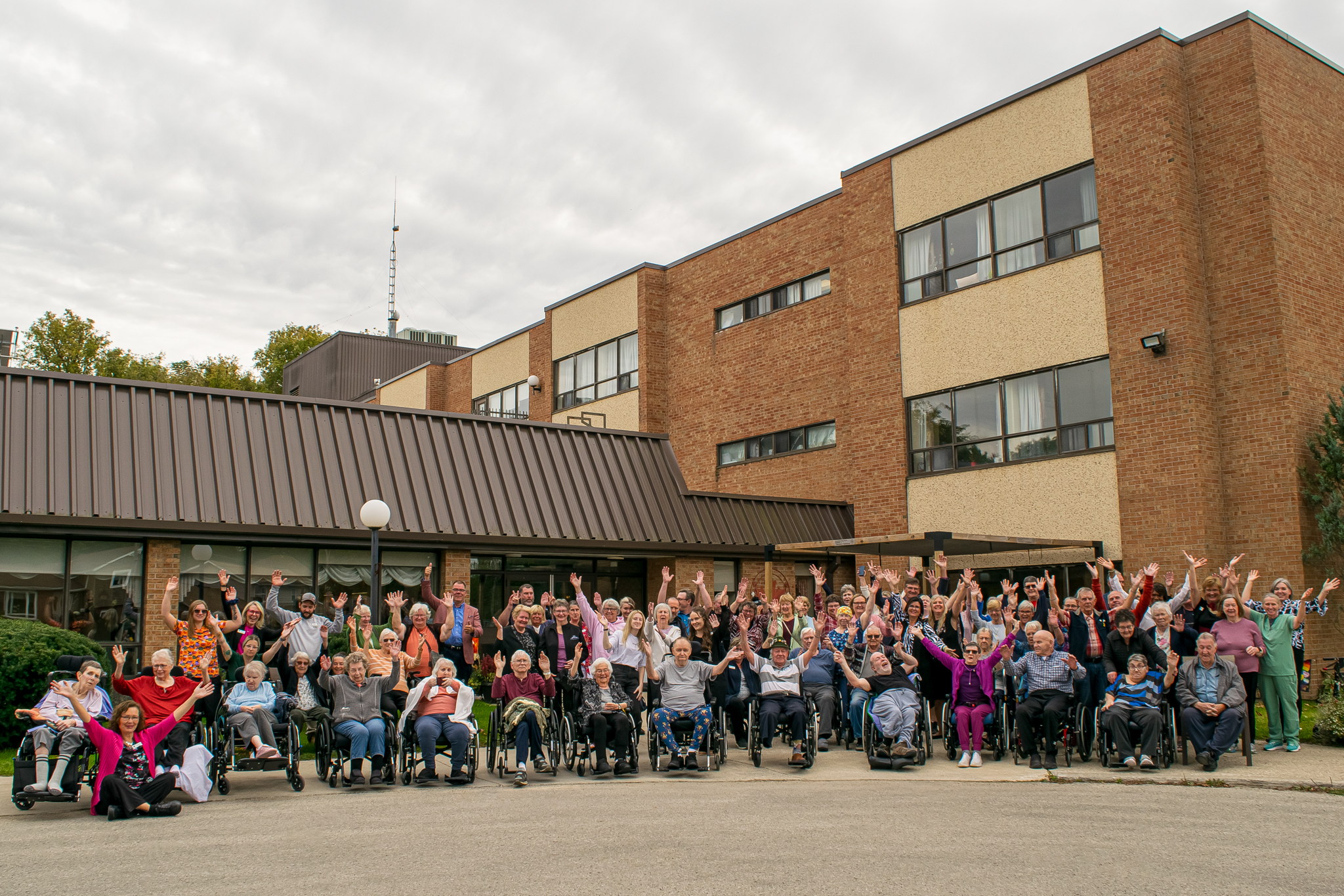 Exterior group shot of Rockwood Terrace residents, resident family members, county staff, and local dignitaries celebrating the long-term care home's 40th anniversary together