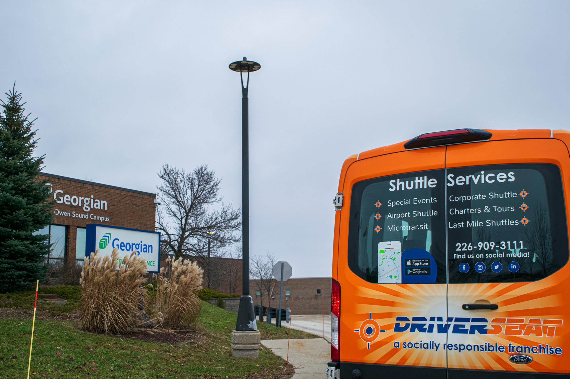 Grey Transit Route Drivers Seat Van in front of Georgian College