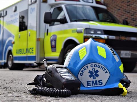 Paramedic gear placed on the ground in front of an ambulance