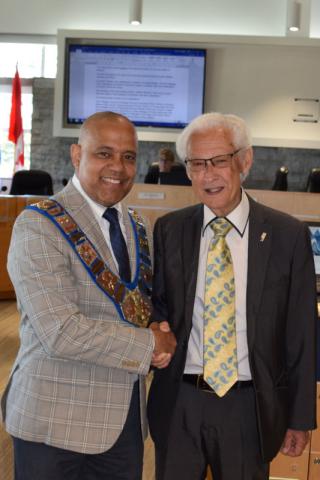 Warden Selwyn Hicks shakes hands with newly sworn in alternate councillor Ross Kentner.