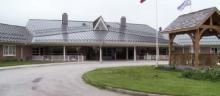 Photo of Grey Gables long term care home facility. There are shrubs in front of the one story building.