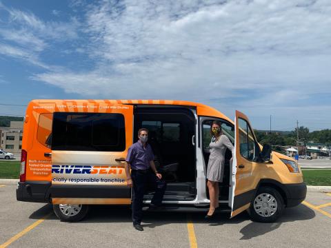 Grey County Warden Paul McQueen (left) climbing into a new Grey Transit Route vehicle with Manager Stephanie Stewart.