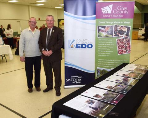 County of Simcoe Warden Gery Marshall stands beside Grey County Warden Alan Barfoot at a business to retail event.