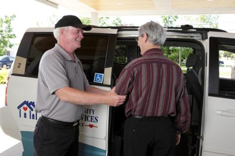 Senior man is helped into an accessible van.