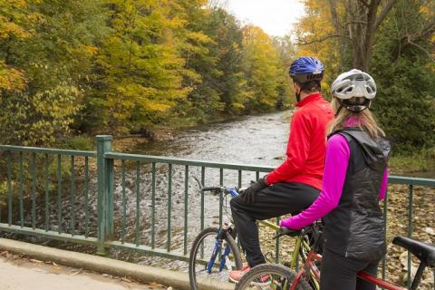 Two cyclists stop to take a break and look at the river in Harrison Park