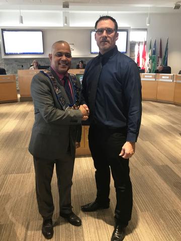 Warden Hicks shakes hands with newly sworn in alternate councillor Shawn Greig