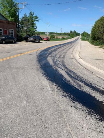 Photo of an intersection with a large amount of black substance on the road surface