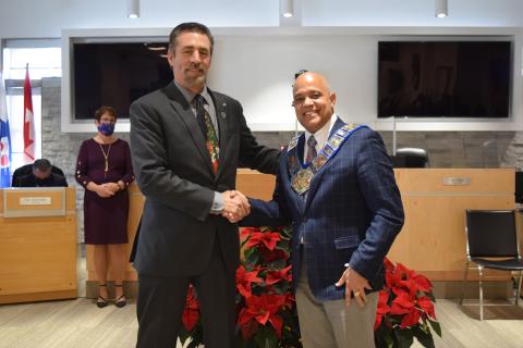 Selwyn Hicks (right) receives the Chain of Office and shakes hands with Past Warden, Paul McQueen.