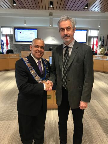 Warden Hicks shakes hands with newly sworn in alternate councillor Geoffrey Shae