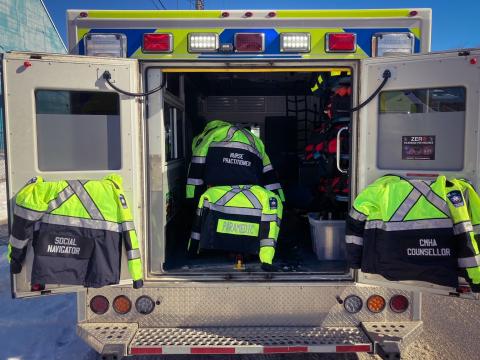 SOS uniforms hanging on the open doors of a Grey County ambulance. 