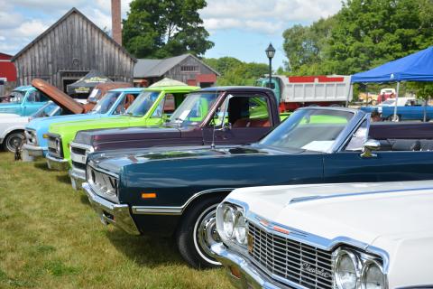 Lineup of classic vehicles parked in Moreston Heritage Village.